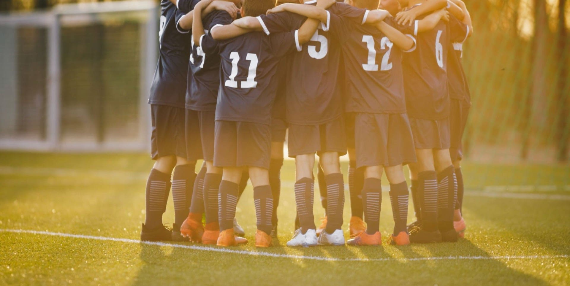 group of kids in a soccer huddle