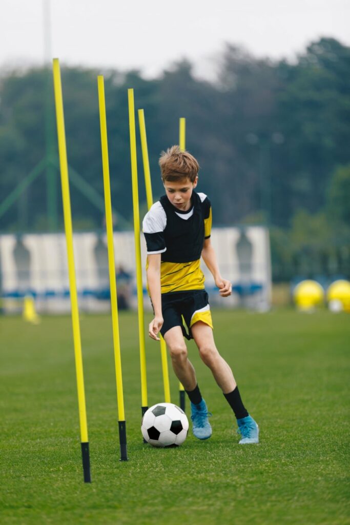 young boy dribbling a soccer ball